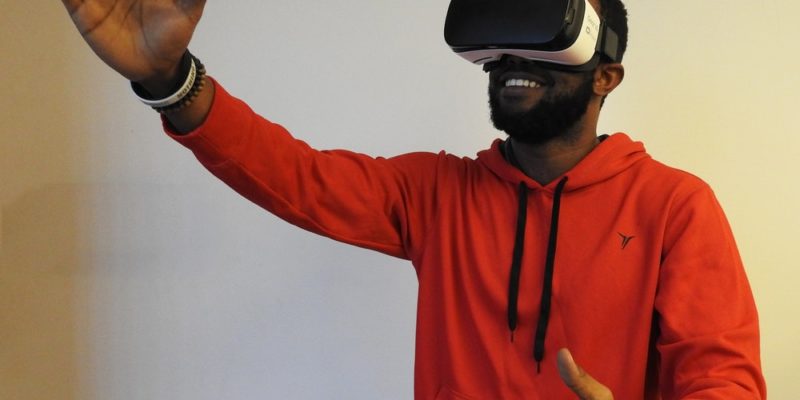man wearing white VR headset while lifting right hand