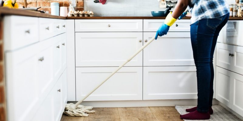 alone cabinets chores cleaning contemporary domestic estate floor gloves home household housework indoors inside kitchen mop person solo woman wooden floor